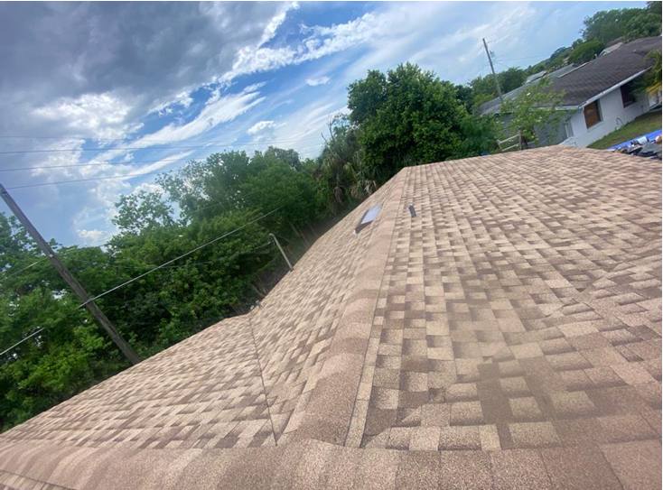 Completed shingle roof against blue sky